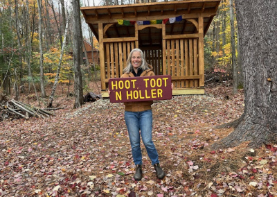 A woman showing off a sign reading hoot, toot and holler